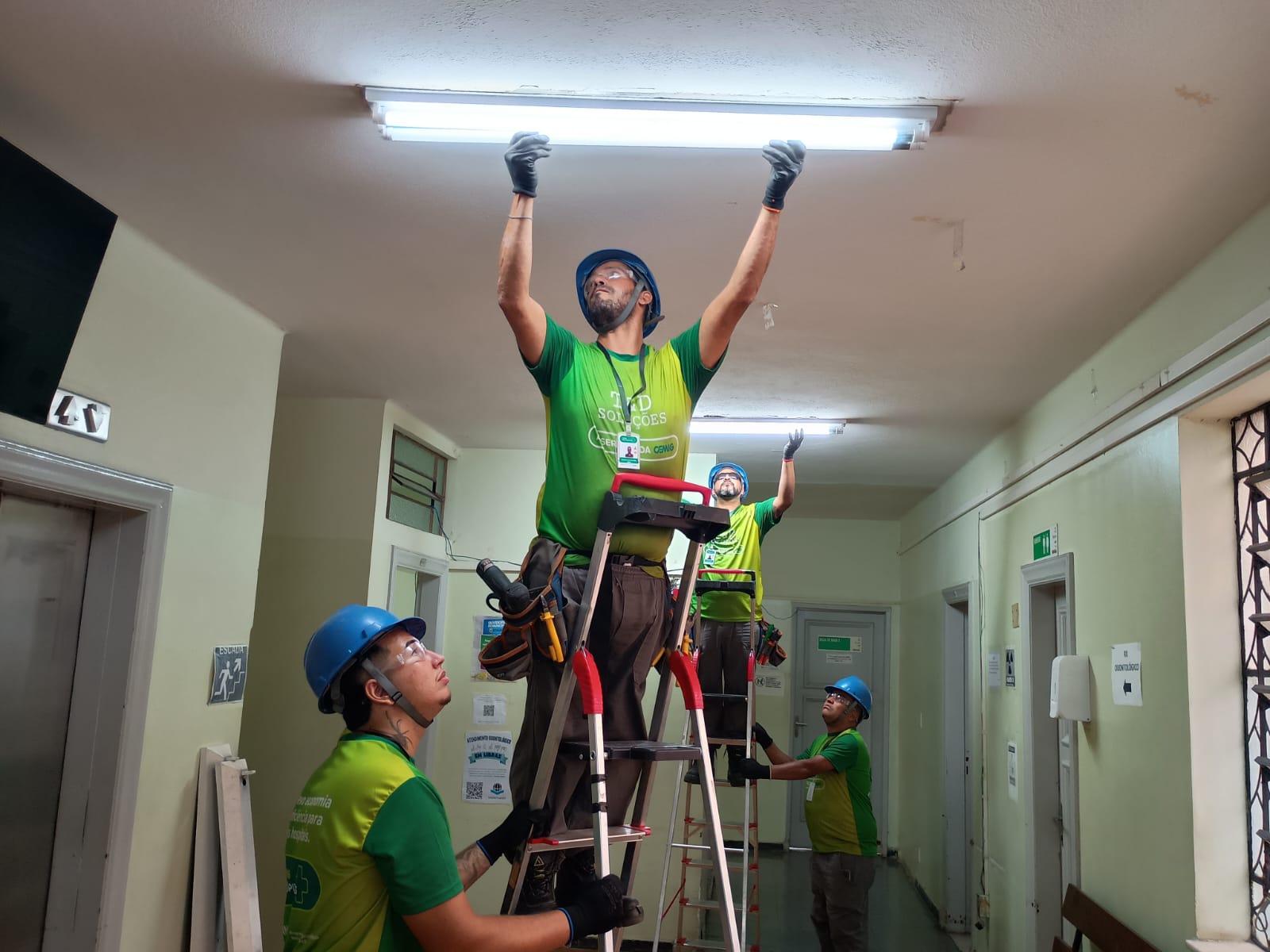 homens trabalhando na troca de lâmpadas
